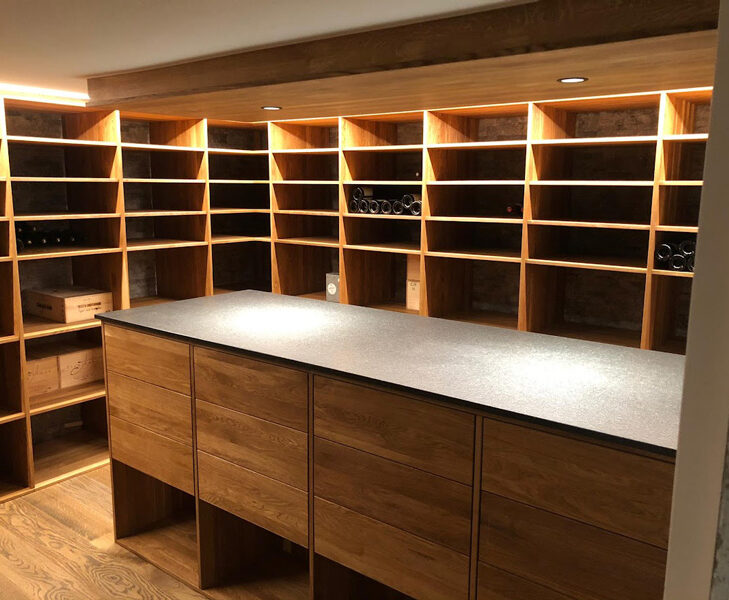 Moderner Weinkeller mit Holzregalen und zentralem Schrank, ideal für stilvolle Weinaufbewahrung und Präsentation.