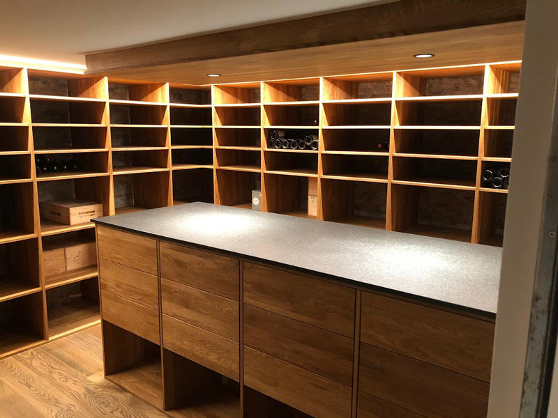 Moderner Weinkeller mit Holzregalen und zentralem Schrank, ideal für stilvolle Weinaufbewahrung und Präsentation.